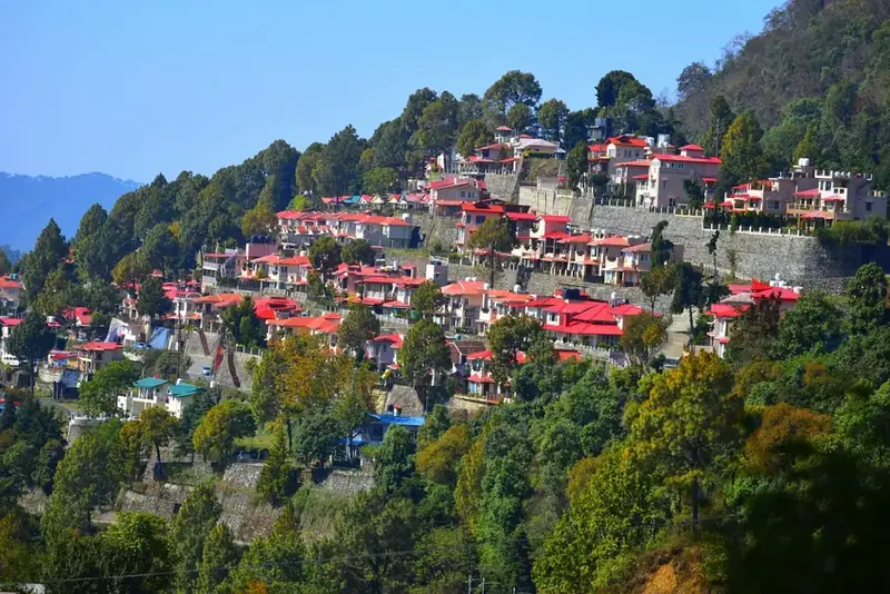 Bhowali hillside town with structures across the forested slope