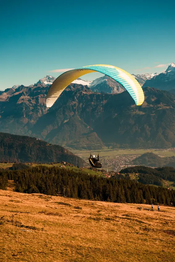 Paragliding adventure soaring over lush mountain valley
